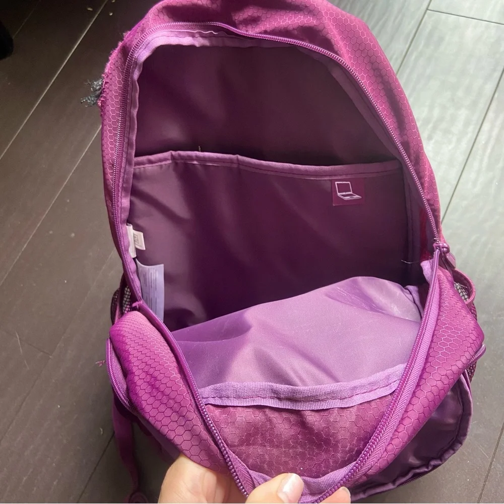Purple Reebok book bag with tear right near strap